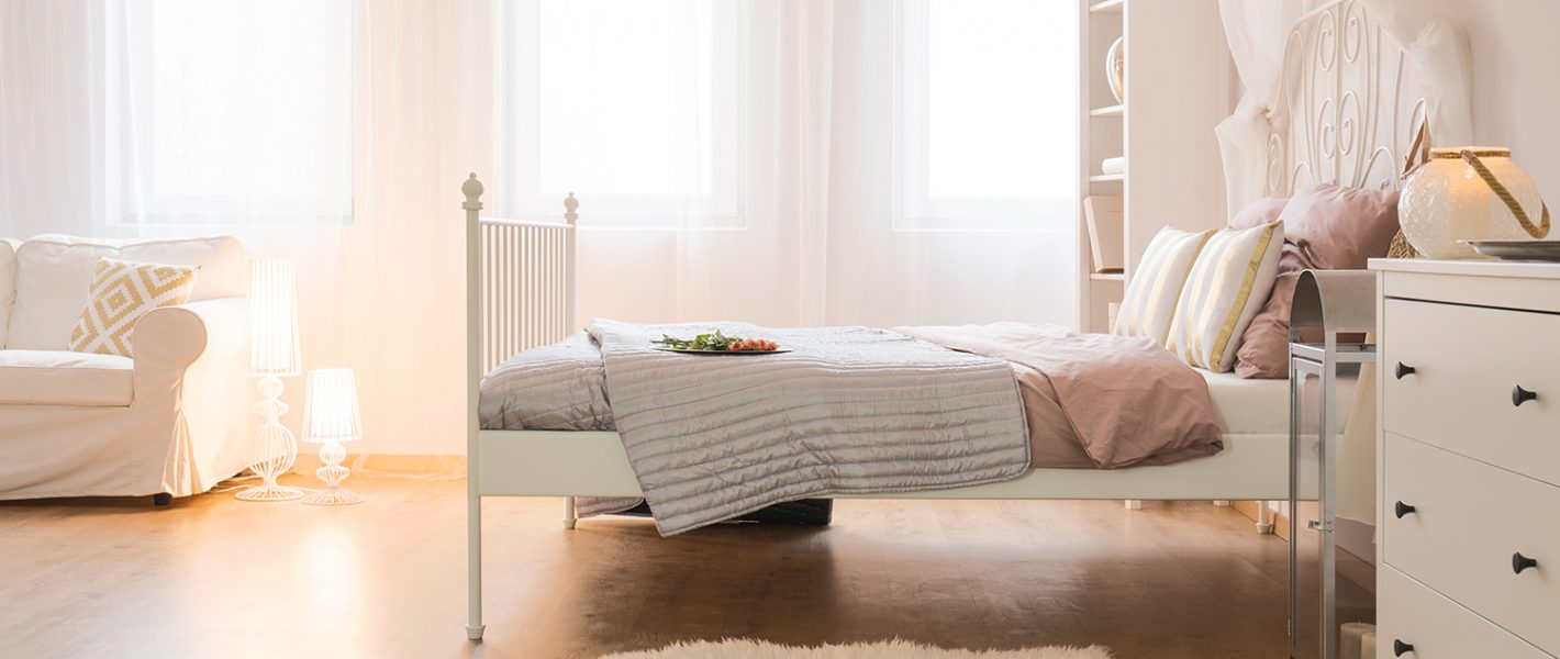 Light home interior with bed, sofa and white dresser